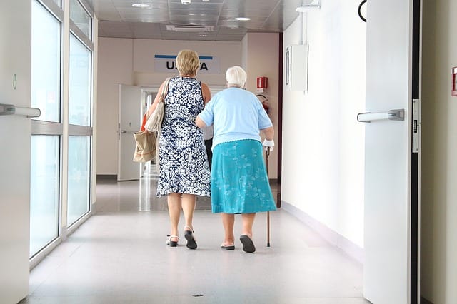 Aidants avec une personnes âgée dans les couloirs d'un hôpital 
